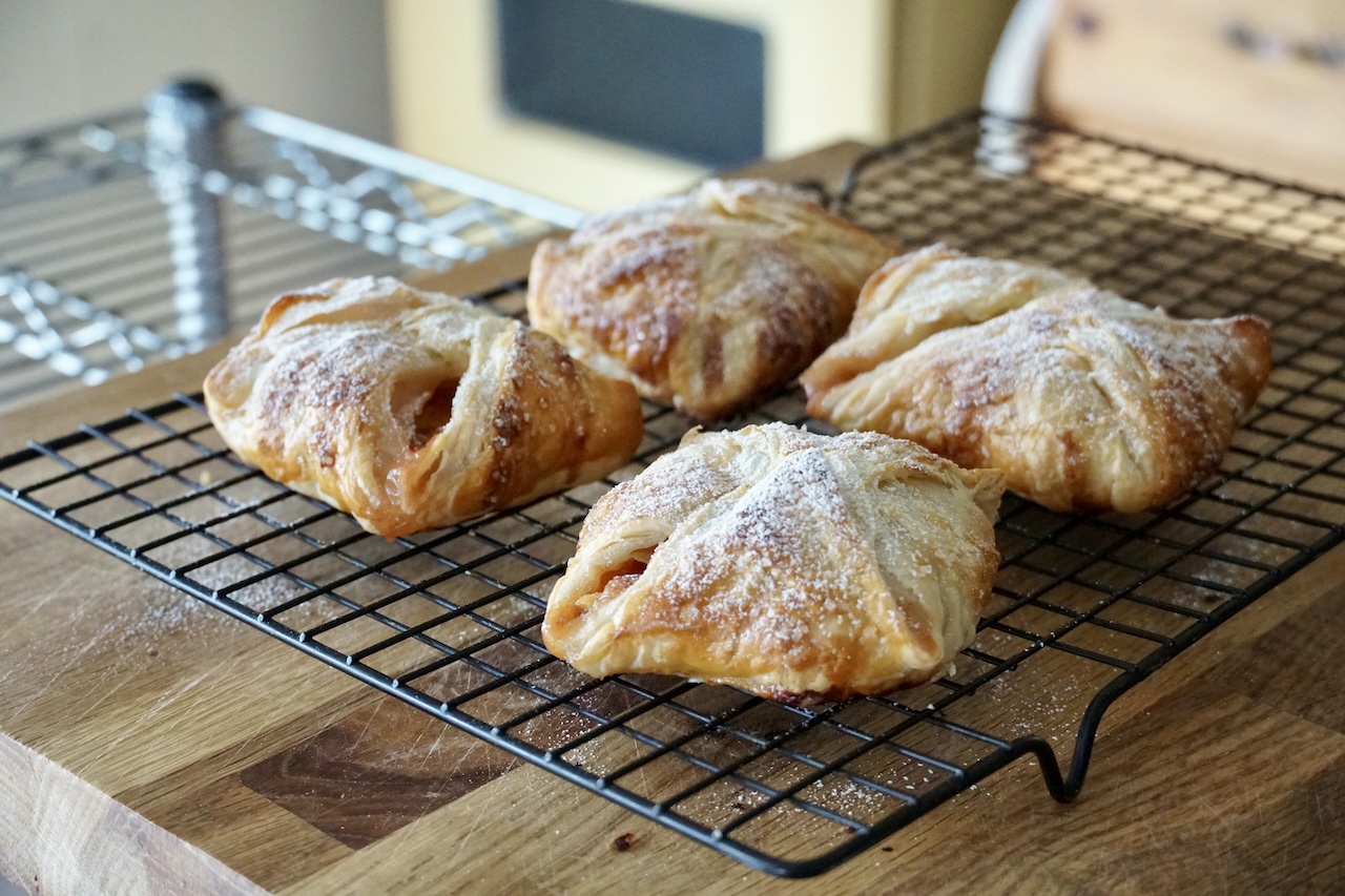 Fresh peach turnovers dusted with icing sugar.