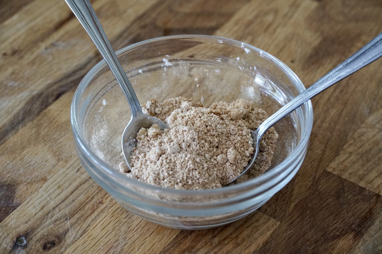 A bowl containing the brown sugar stirred with cornstarch, salt, cinnamon and ground ginger.