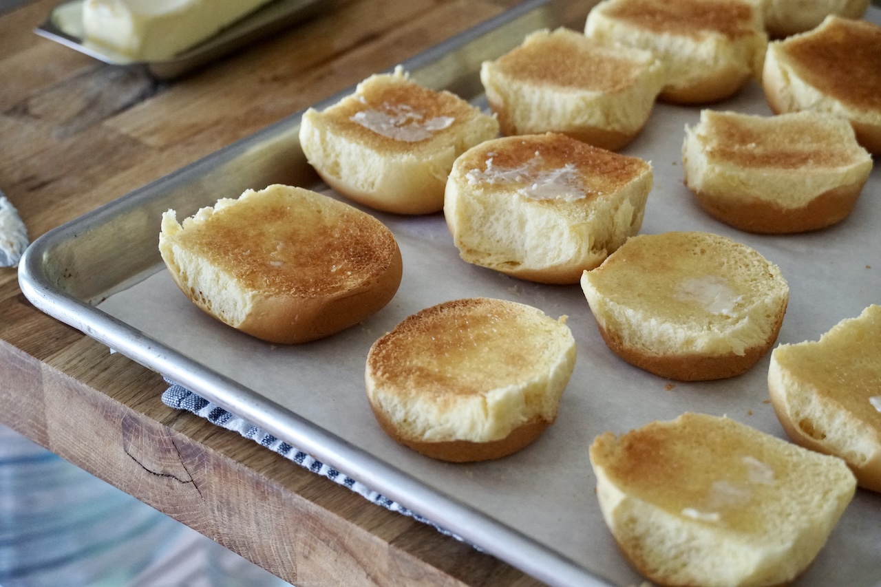 Toasted mini slider buns topped with a swipe of butter.