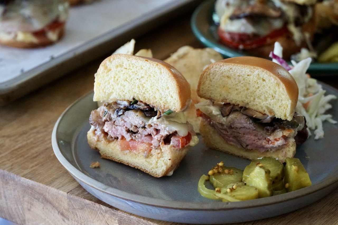 One of the Grilled Steak Sandwiches cut in half to reveal the interior.