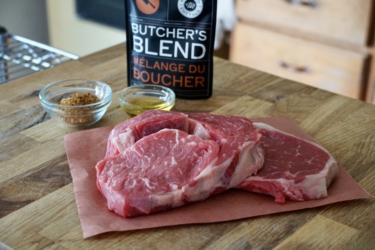 Two 8-ounce ribeye steaks plus a bowl of Butcher's Blend steak seasoning blend.