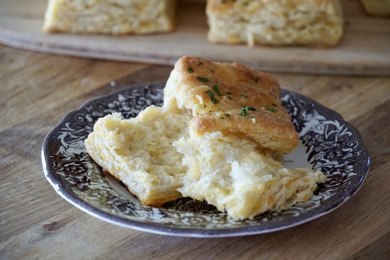 An apple cheddar biscuit pulled apart to show the flaky layers.