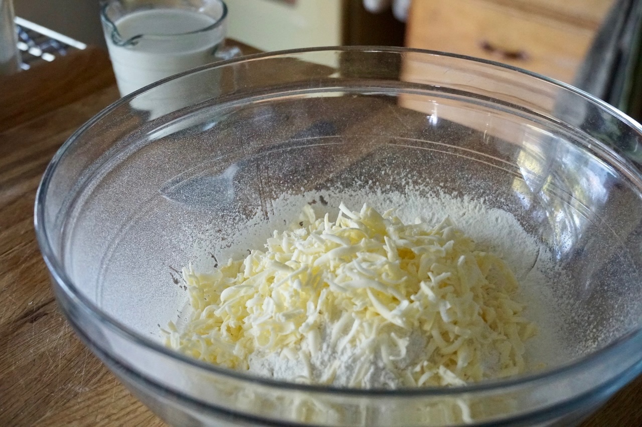 Frozen butter grated into the large bowl containing the sifted dry mixture.