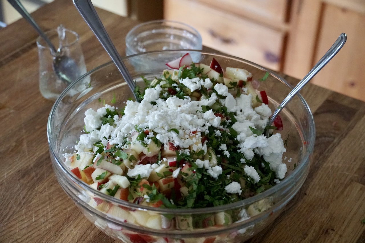 A large bowl containing all of the ingredients for the crunchy apple salad.