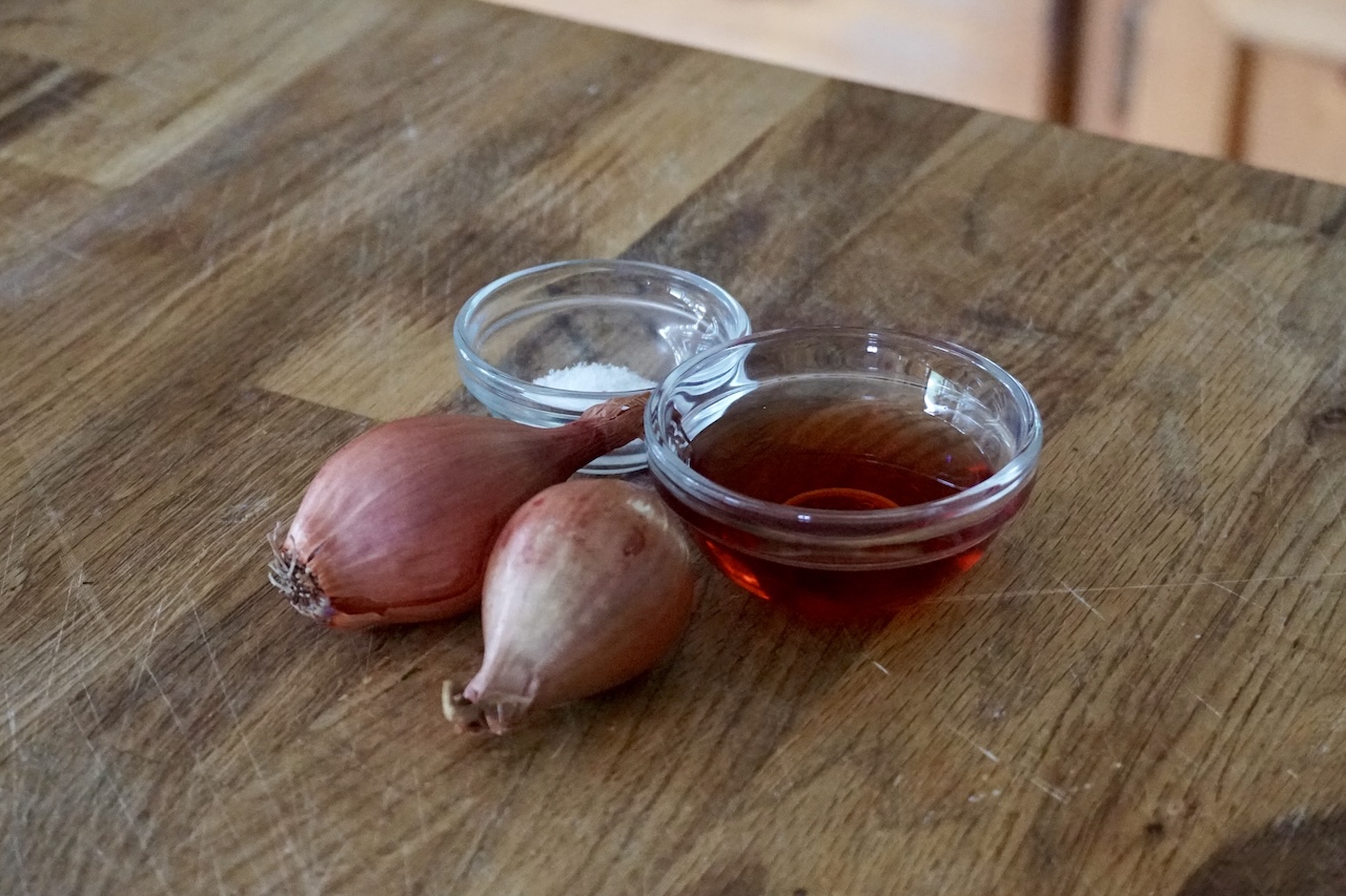A bowl of red wine vinegar, some kosher salt and a couple of shallots.