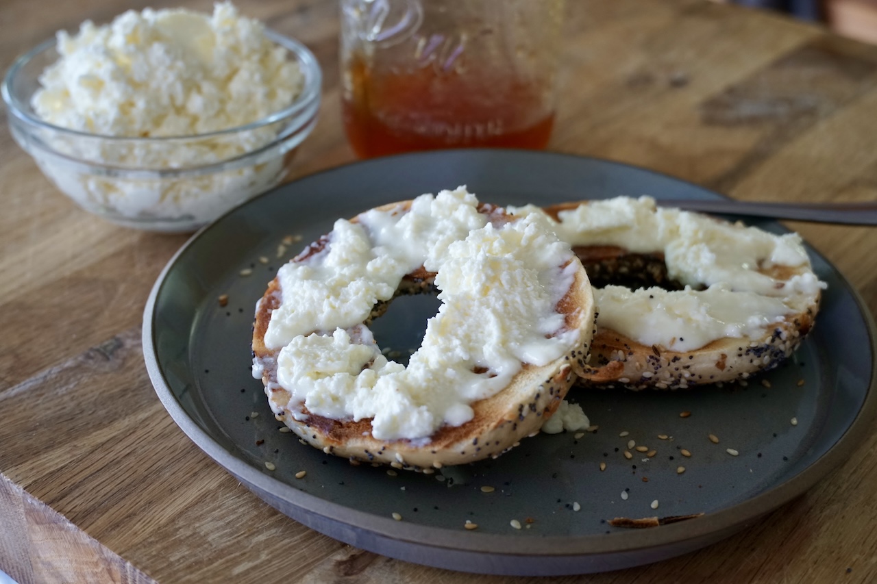 Extra kajmak spread onto a toasted everything bagel.