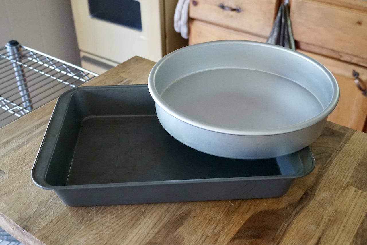Two baking pans; one rectangular, the other circular.