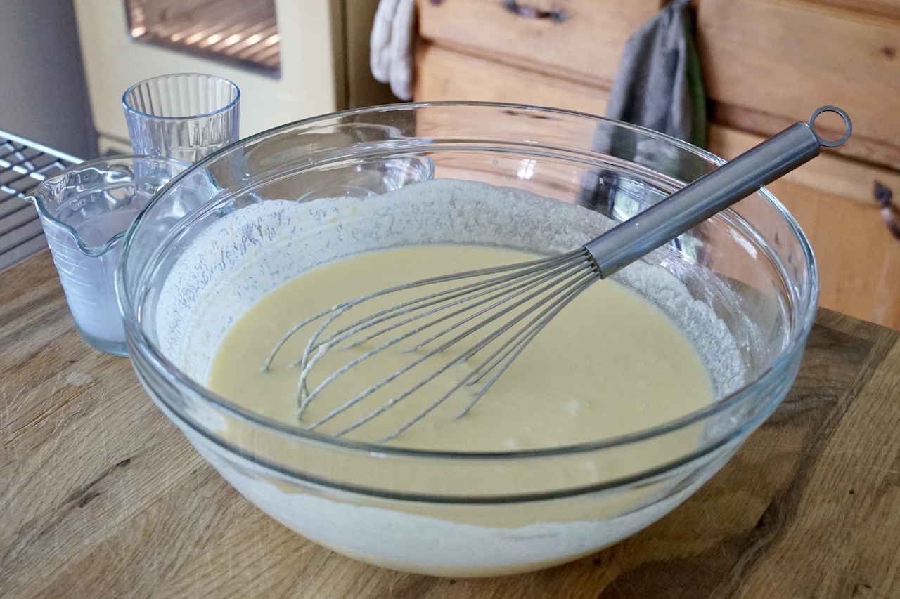A large mixing bowl containing the egg and cheese mixture.