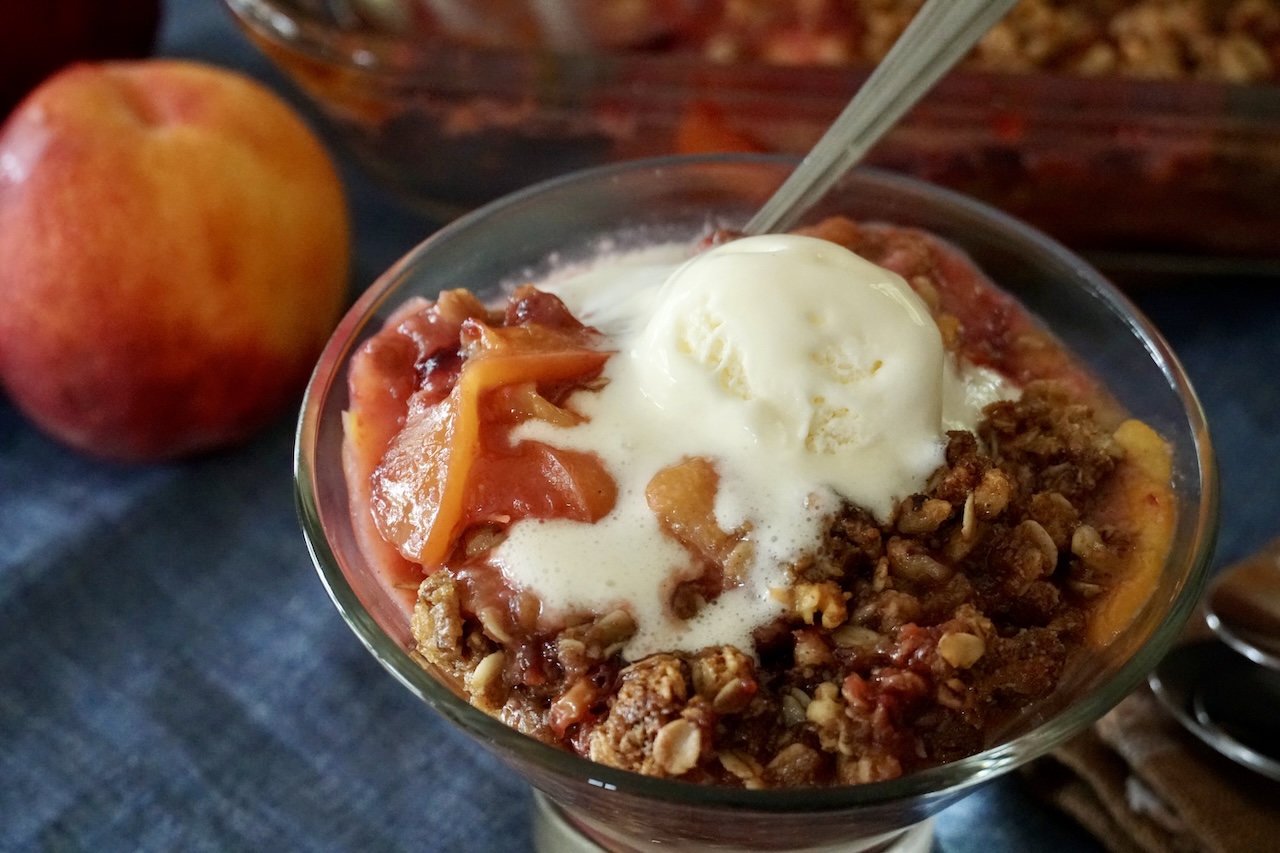 A close up of the fresh fruit crisp served with vanilla ice cream.
