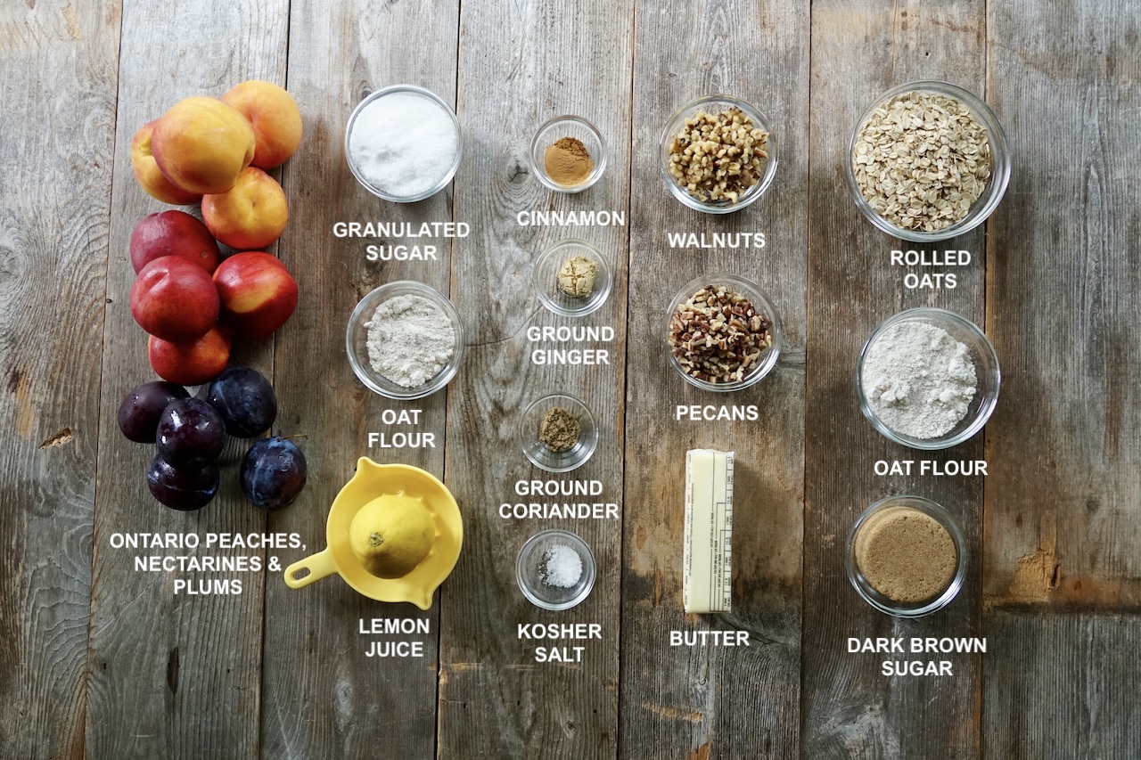 All of the ingredients needed to make a fresh fruit crisp laid out on a large surface.