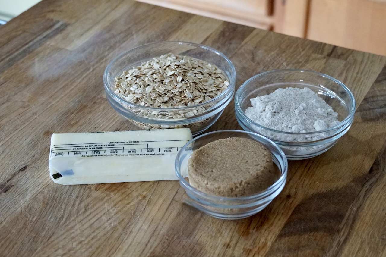 Bowls or rolled oats, dark brown sugar, oat flour and a stick of butter.