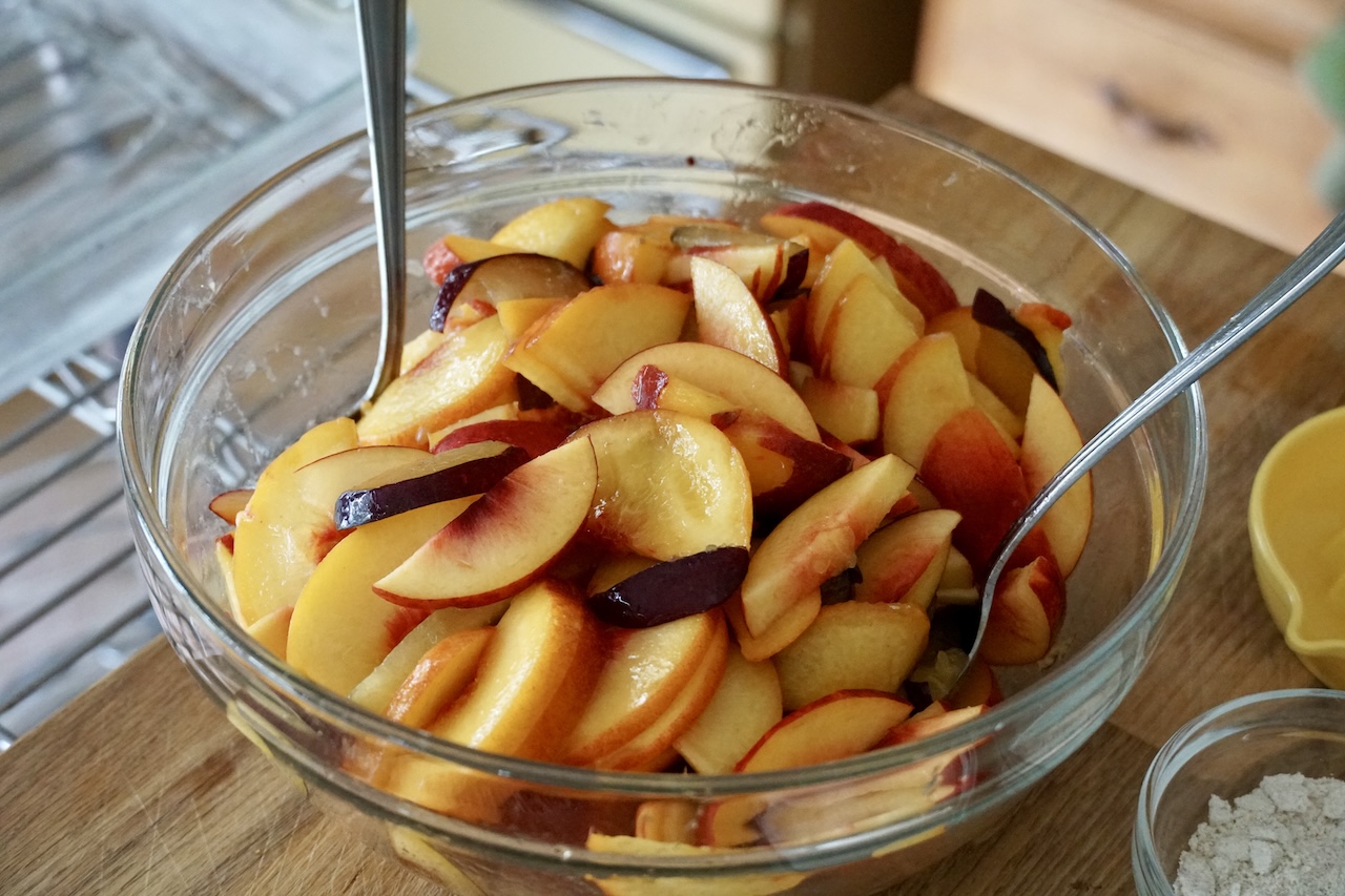 A bowl containing fresh peaches, nectarines and plums.