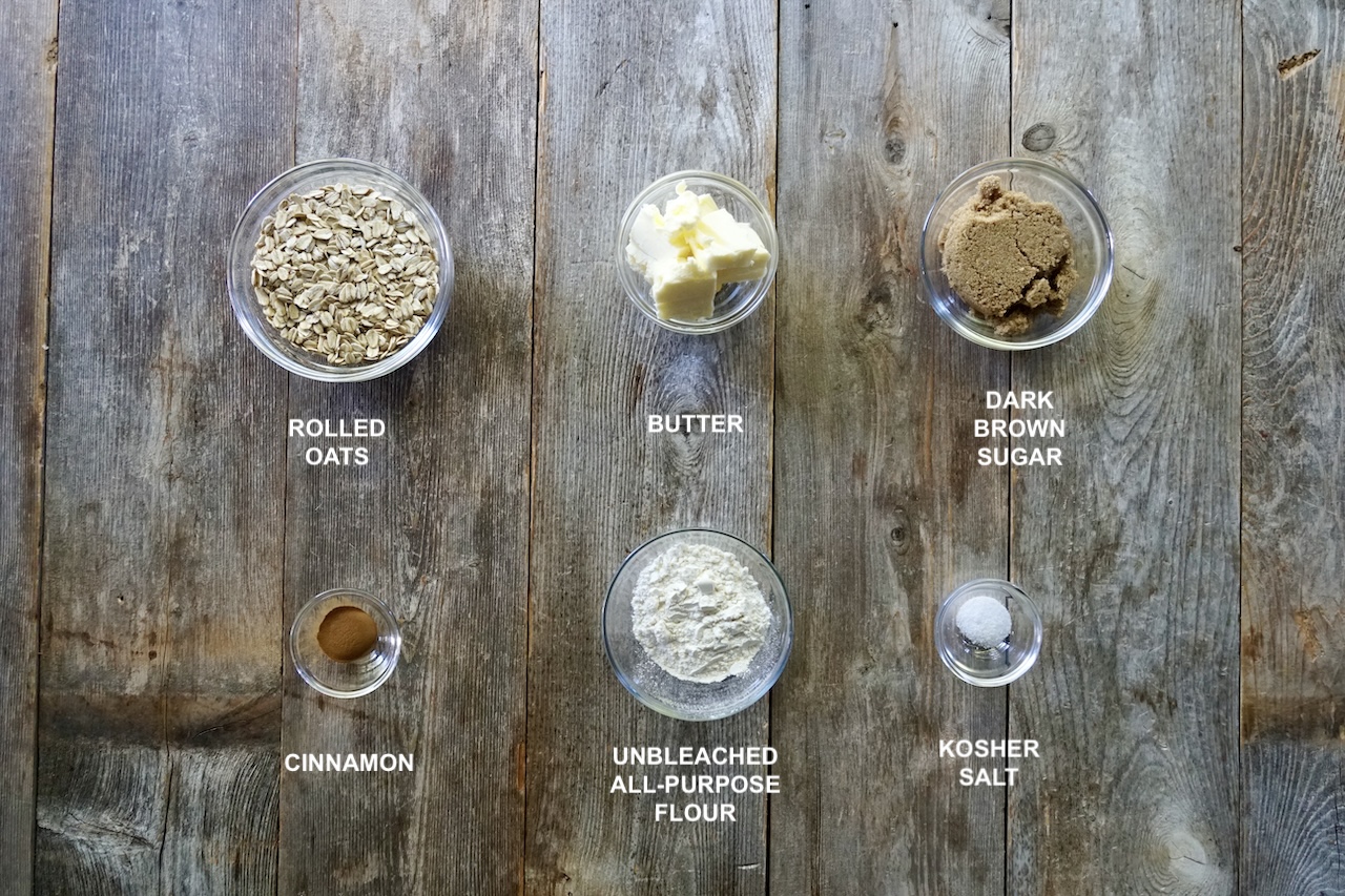 Ingredients for the crumble topping assembled in small bowls include: rolled oats, butter, brown sugar, cinnamon, flour and kosher salt.