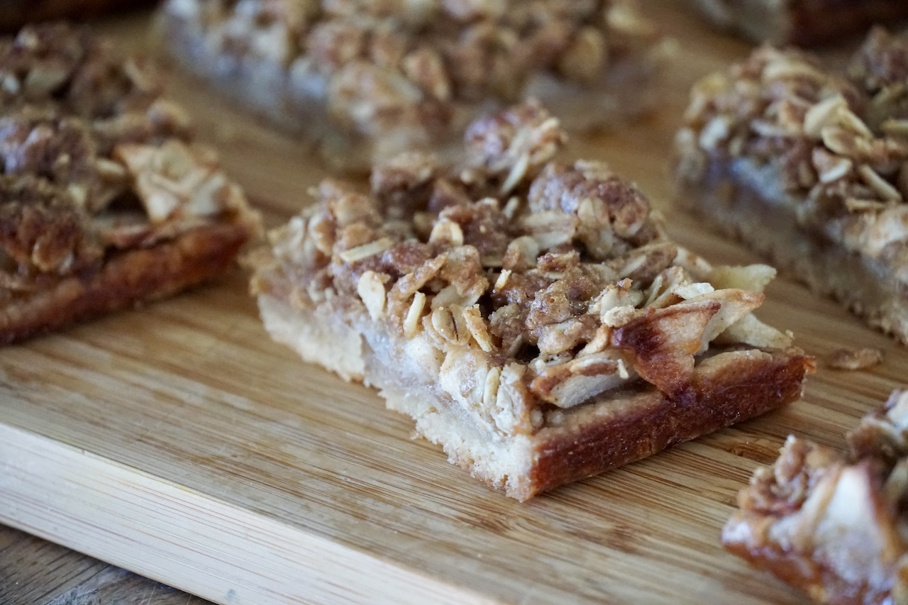Apple Pie Crumble Bars presented on a wooden board.