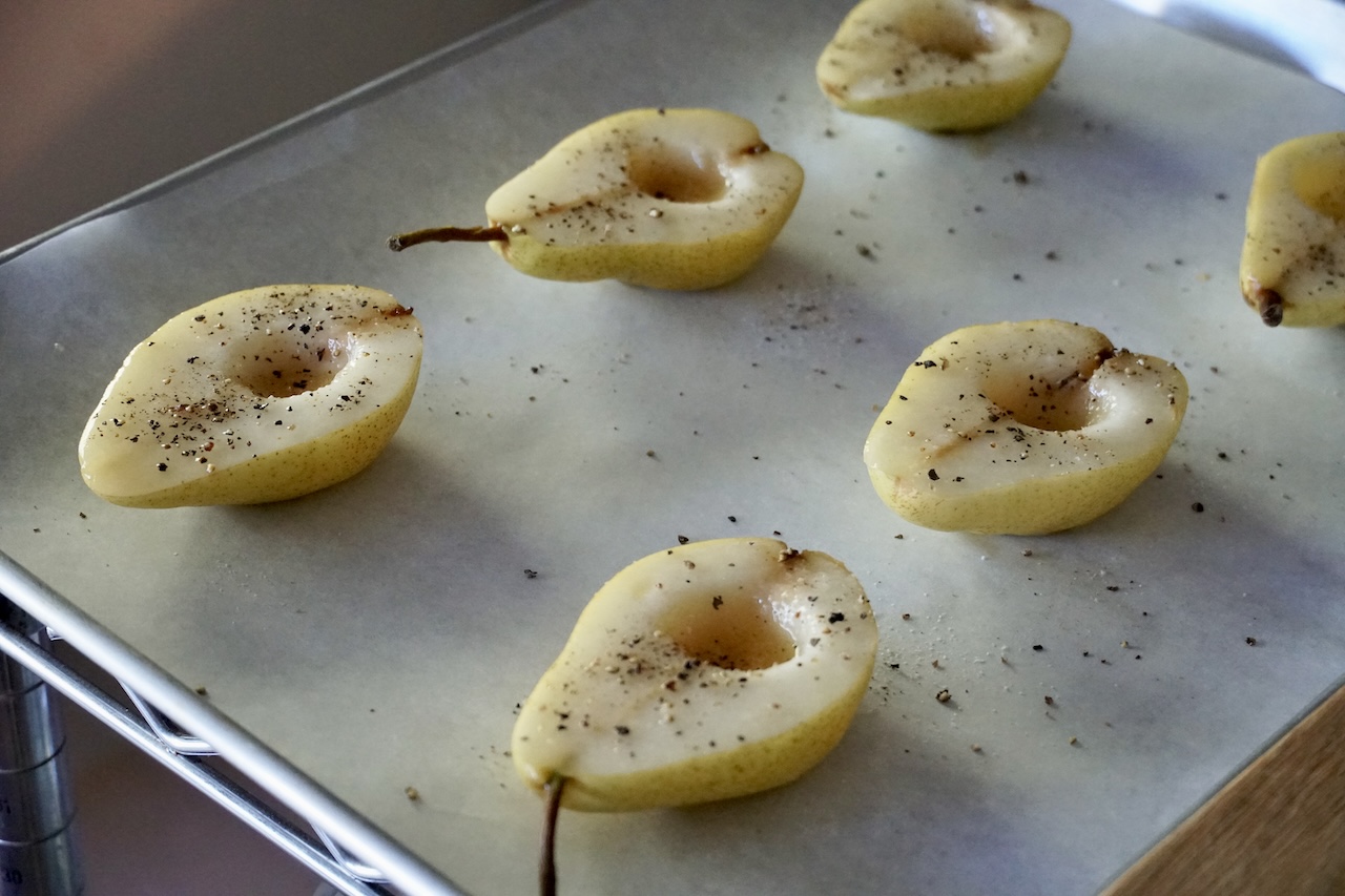 Pears divided in half brushed with maple syrup and butter.