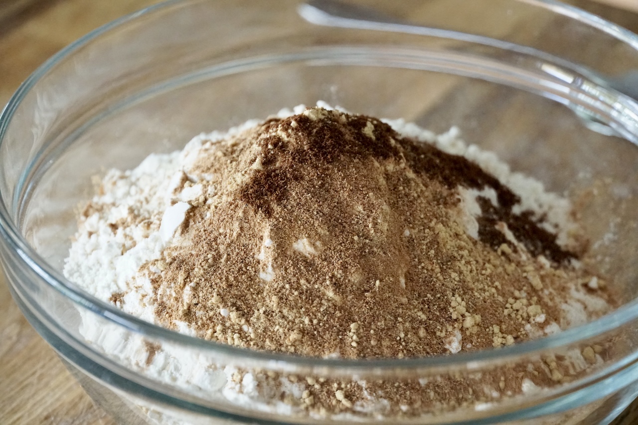 The dry ingredients for the pumpkin spice cake poured into a medium bowl.