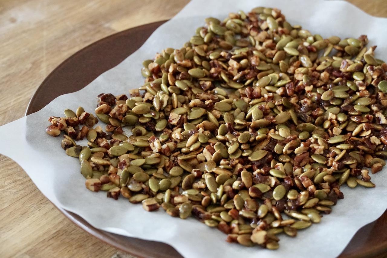 The candied nut and pumpkin seed topping chilling on a piece of parchment paper.