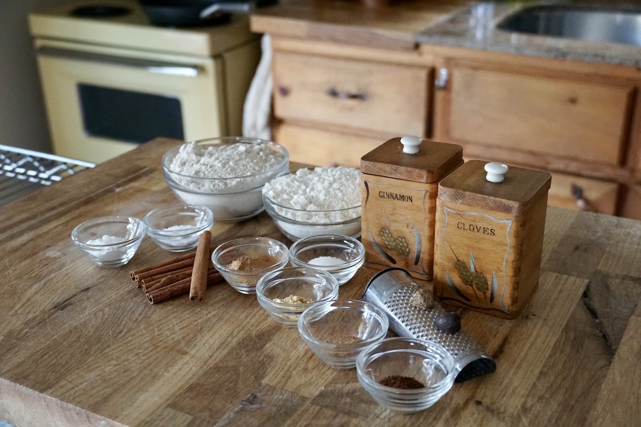 The ingredients for the dry mixture for the spiced pumpkin cake laid out in small bowls.