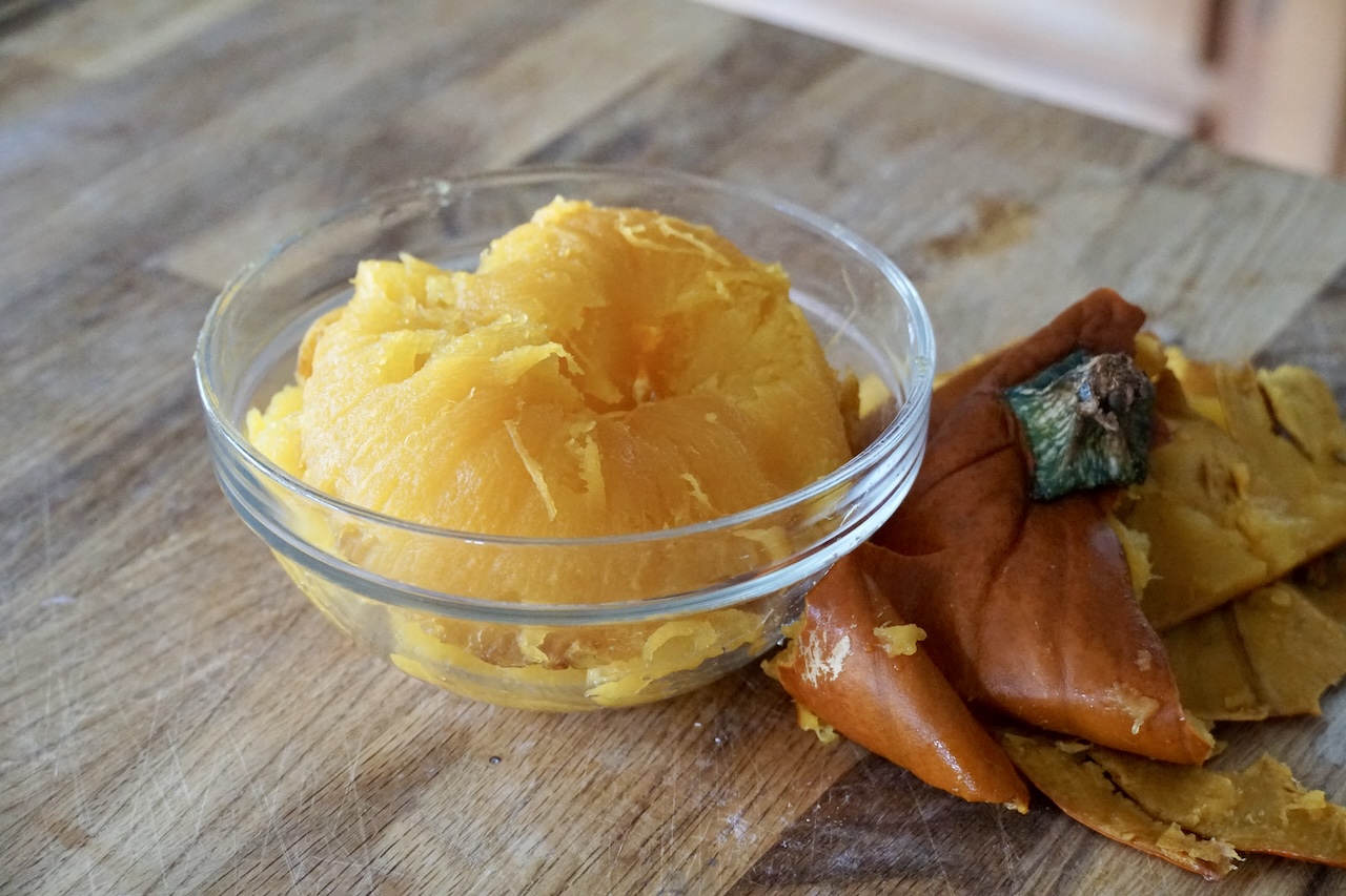 The flesh of a freshly roasted sugar pumpkin scooped out into a small glass bowl.