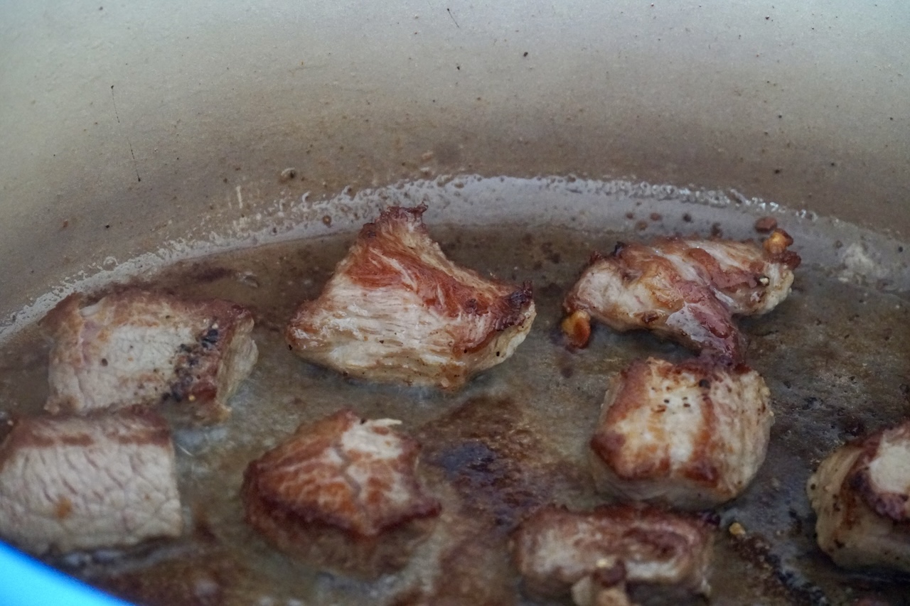 Chunks of veal searing in a hot stew pot.