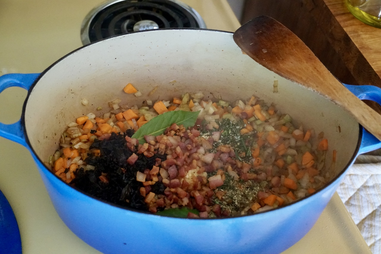 The pot topped up with the aromatics and seared pancetta.
