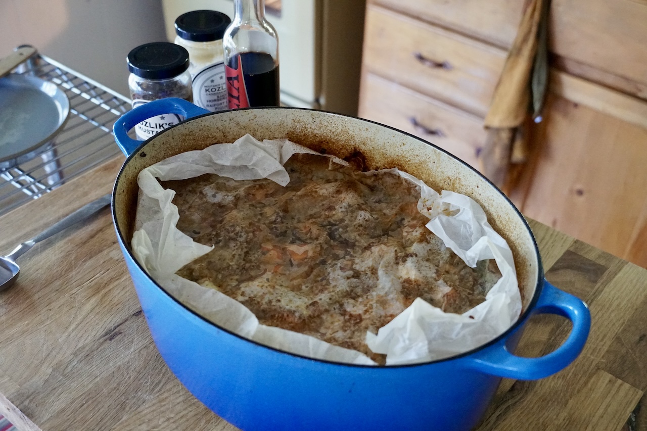 The top of the stew pot covered with a parchment paper cartouche.