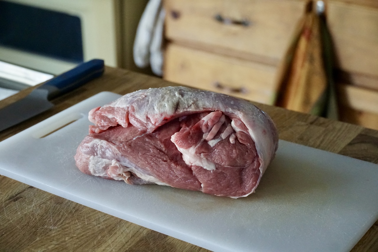 A piece of veal shoulder meat resting on a cutting board.
